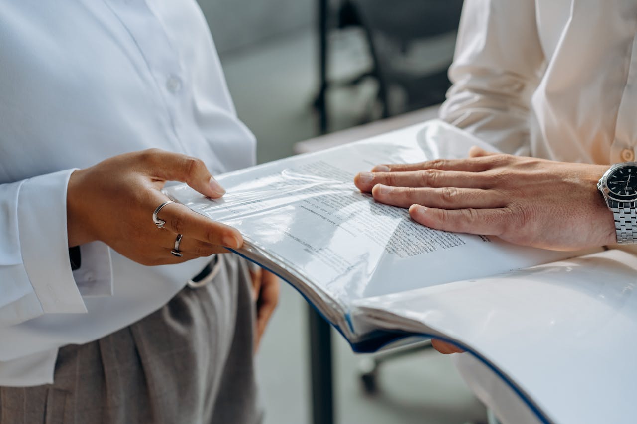 About Two professionals examining business documents during a meeting indoors.
